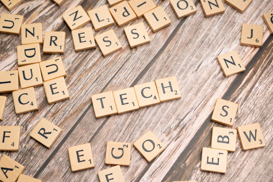 Wooden Scrabble tiles spelling TECH on a textured surface.